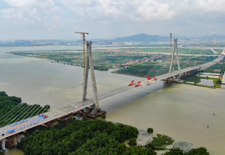 南中高速連通廣州、中山、深圳三市，是國家高速公路網(wǎng)G2518和廣東省高速公路網(wǎng)S78的重要組成部分，也是粵港澳大灣區(qū)重大交通基礎(chǔ)設(shè)施項目。其中的洪奇門特大橋全長1126米，為主跨520米的雙塔雙索面鋼箱梁斜拉橋，是南中高速項目的關(guān)鍵控制性工程。2023年5月21日上午，南中高速洪奇門特大橋順利合龍，實現(xiàn)了廣州、中山兩市實現(xiàn)跨江“牽手”。圖為南中高速洪奇門特大橋。