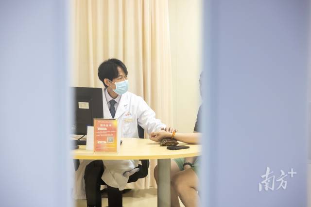 梁偉衡在給病人看診。
