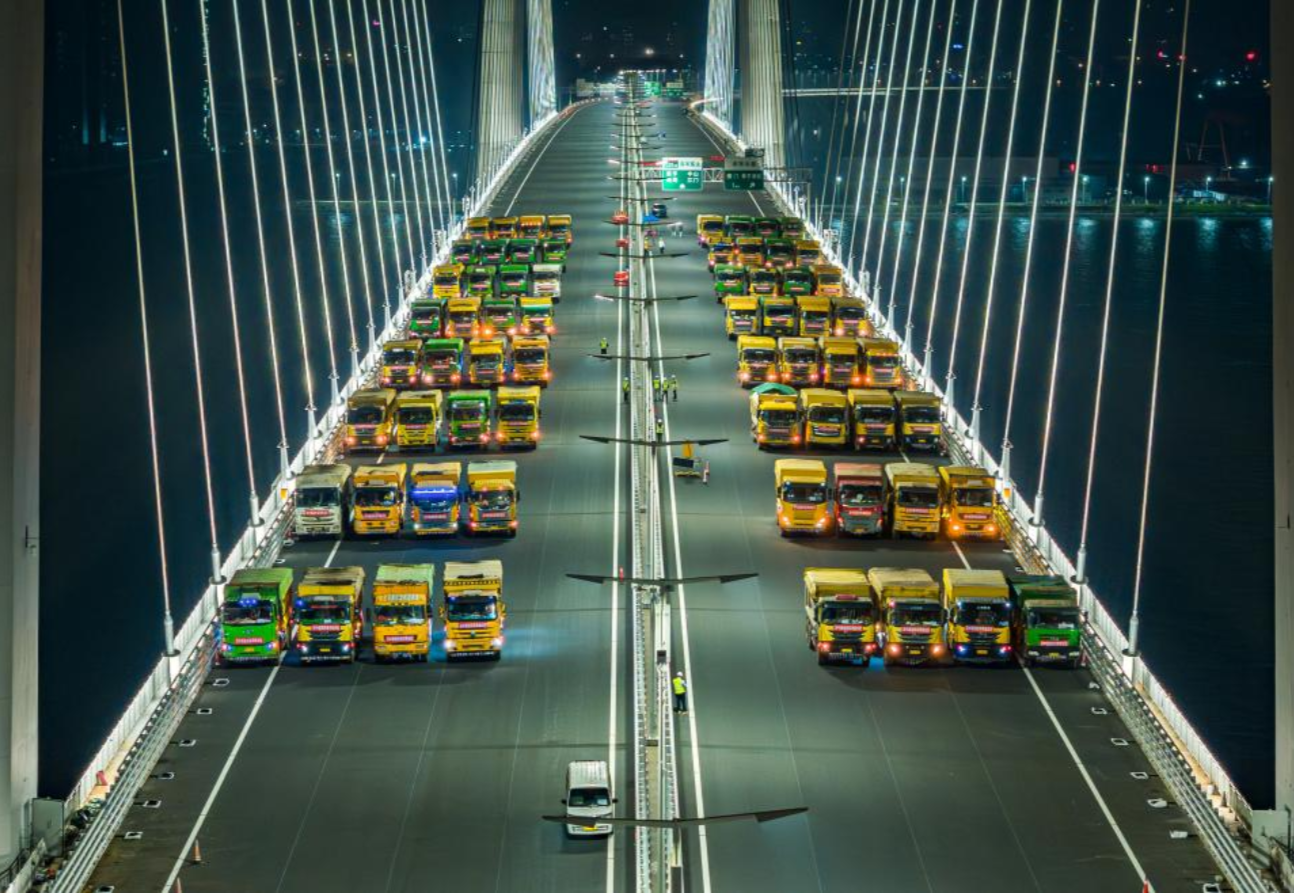 2024年4月17日，深中通道橋梁工程完成荷載試驗。最大達(dá)136輛、總重約5000噸的大貨車組對深中通道中山大橋、深中大橋非通航孔引橋進行荷載試驗，通過等效模擬通車后的荷載情況，現(xiàn)場測試橋梁各部位的反應(yīng)數(shù)據(jù)，判斷橋梁承載能力是否符合設(shè)計要求和相關(guān)規(guī)范要求，為交工驗收提供原始數(shù)據(jù)。圖為大貨車組為深中通道進行橋梁荷載試驗。
