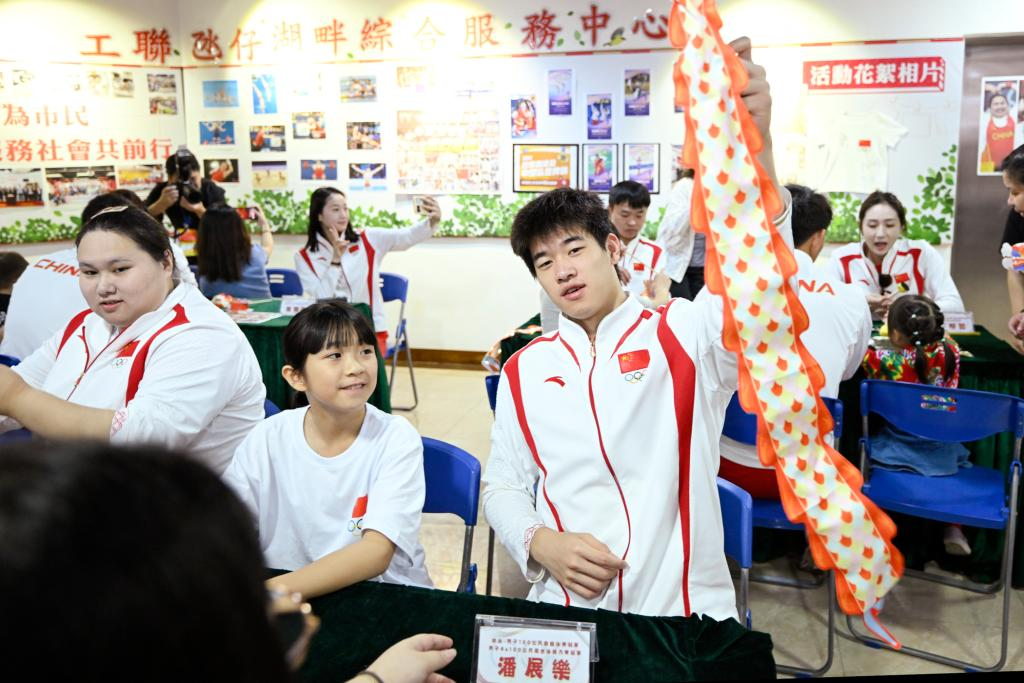 9月2日，在澳門工聯(lián)氹仔湖畔綜合服務(wù)中心，游泳運(yùn)動(dòng)員潘展樂(lè)（右）展示與小朋友一起制作的燈籠。當(dāng)日，內(nèi)地奧運(yùn)健兒代表團(tuán)走進(jìn)澳門社區(qū)，分別到婦聯(lián)樂(lè)滿家庭服務(wù)中心、街總石排灣家庭及社區(qū)綜合服務(wù)中心和工聯(lián)氹仔湖畔綜合服務(wù)中心與市民互動(dòng)。新華社發(fā)