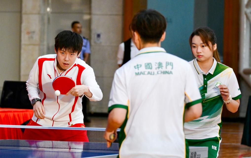 9月1日，乒乓球運(yùn)動(dòng)員王楚欽（左）與澳門運(yùn)動(dòng)員切磋球技。當(dāng)日，內(nèi)地奧運(yùn)健兒代表團(tuán)在澳門奧林匹克體育中心室內(nèi)體育館與澳門青少年運(yùn)動(dòng)員進(jìn)行互動(dòng)交流。新華社記者 郭雨祺 攝