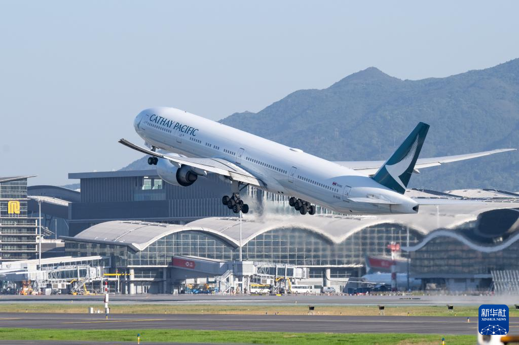 11月28日，香港國際機(jī)場三跑道系統(tǒng)正式啟用后，一架飛機(jī)從中跑道起飛。新華社記者 朱煒 攝