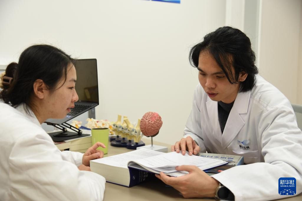 澳門醫(yī)生繆永銳（右）和同事進(jìn)行交流（12月17日攝）。新華社記者 洪澤華 攝