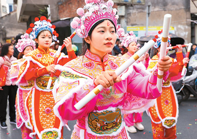  春節(jié)期間，英歌舞隊員在廣東省汕頭市潮陽區(qū)海門鎮(zhèn)街頭巡游表演。王文攝（人民視覺）